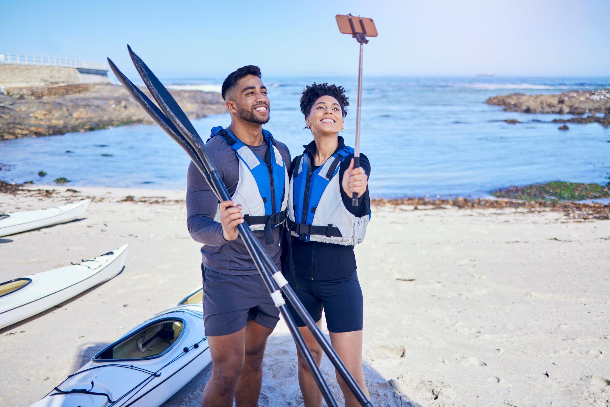 Couple taking a selfie on the beach after kayaking