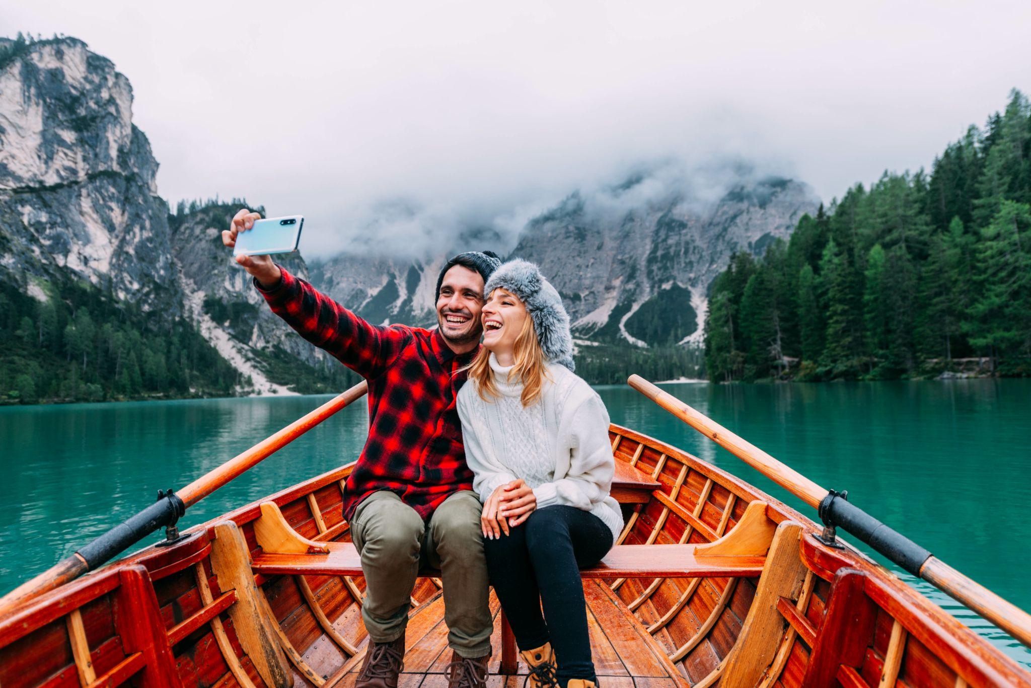 Happy couple taking a selfie on a boat in the winter