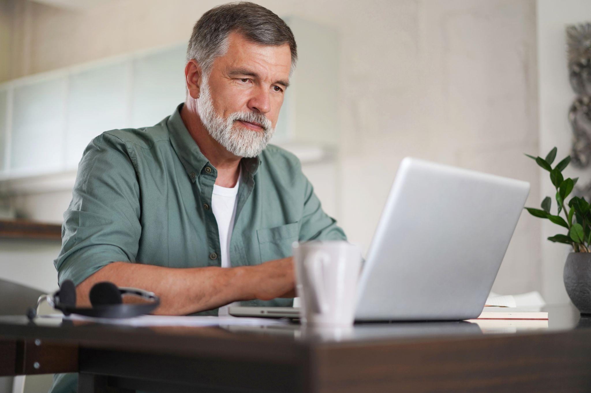 Middle aged man on social media on laptop